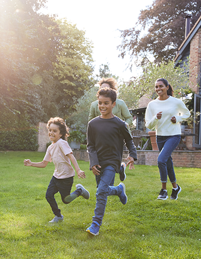 Family playing together in the yard outside their home